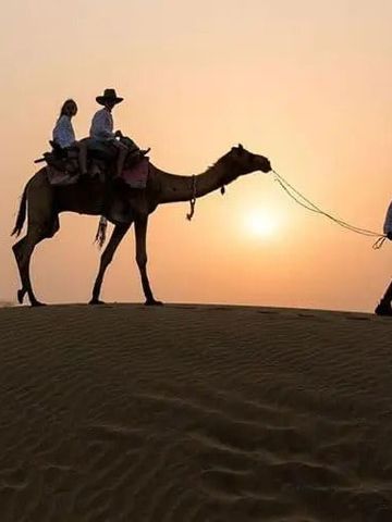 Kamelritt bei Sonnenuntergang in der Wüste nahe Serengeti Safari Camp