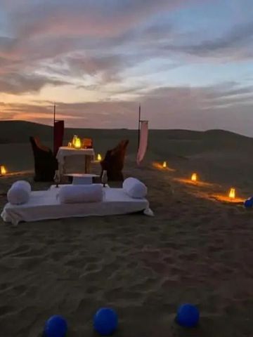 Privates Abendessen auf beleuchtetem Sand in der Dämmerung