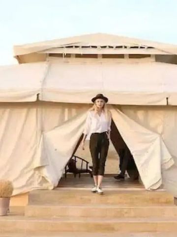 Eingang eines luxuriösen Safari-Zeltes mit offener Tür und hellen Stoffwänden