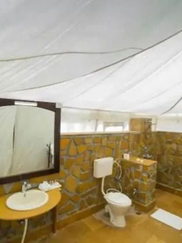 Geräumiges Badezimmer in einem Safari-Zelt mit Steinwänden und moderner Ausstattung