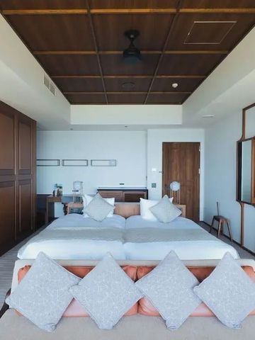 Lichtdurchflutetes Schlafzimmer mit großen Fenstern und luxuriösem Bett