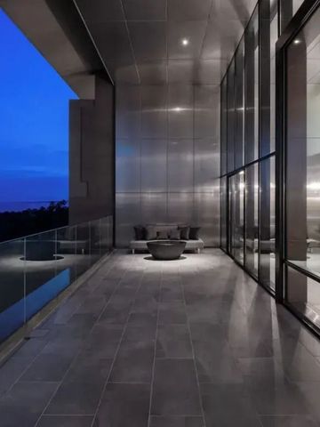 Geräumige Terrasse mit Glasgeländer und abendlicher Aussicht in modernen Architektur.