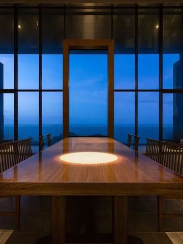 Luxuriöser Besprechungsraum mit großer Fensterfront und Holztisch.