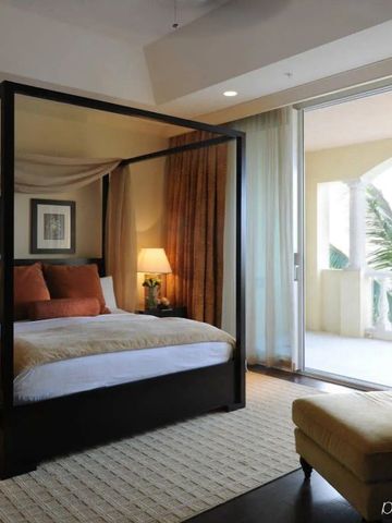Geräumiges Schlafzimmer mit Himmelbett und Balkon im Grace Bay Club