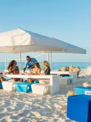 Strandlounge mit Sonnenschirmen und Meerblick am Grace Bay Club
