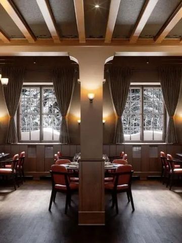 Elegantes Restaurant mit dunklem Holzdekor und verschneitem Ausblick
