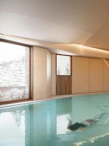 Luxuriöser Innenpool mit Holzdetails und großen Fenstern mit Winterblick