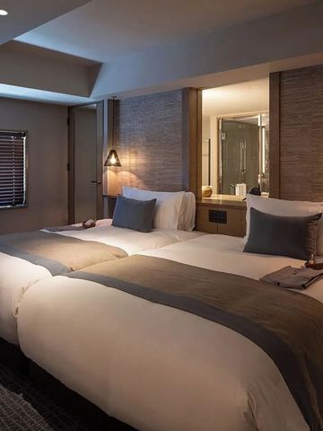 Gemütliches Doppelzimmer mit weicher Beleuchtung und großem Fenster