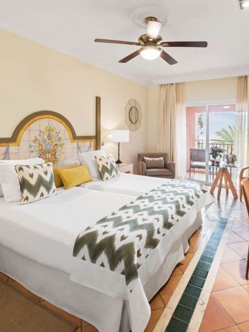 Helles Hotelzimmer mit zwei Einzelbetten und mediterranem Dekor