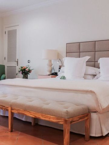 Geräumiges Gästezimmer mit großem Bett und eleganter Einrichtung.