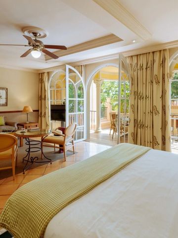 Lichtdurchflutetes Hotelzimmer mit Balkon und gemütlichem Sitzbereich.