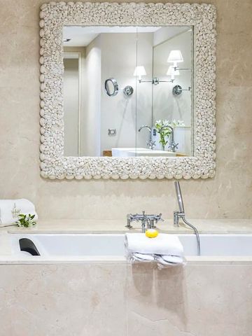 Luxuriöses Badezimmer mit dekorativem Spiegel und großzügiger Badewanne.