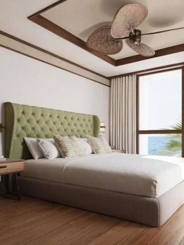 Modernes Hotelzimmer mit großem Bett und Meerblick durch ein großes Fenster