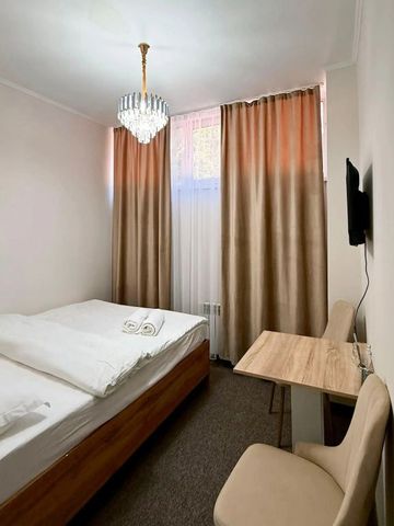 Gemütliches Hotelzimmer mit Bett, TV und großem Fenster mit Vorhängen