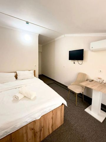 Modernes Doppelzimmer mit Bett, Tisch und Wand-TV