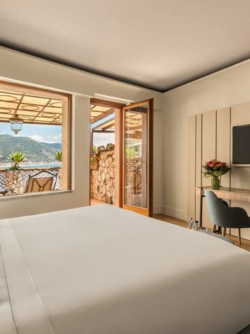 Hotelzimmer mit Doppelbett und Balkon mit Bergblick