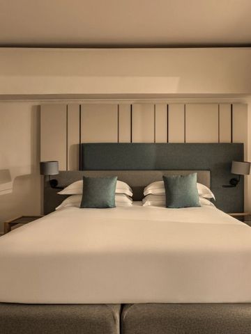 Modernes Hotelzimmer mit großem Bett und stilvollen Kissen