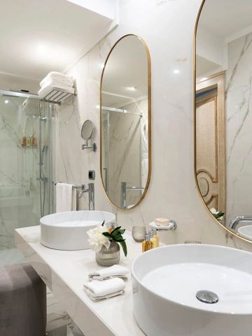 Badezimmer mit Doppelwaschbecken und großer Duschkabine