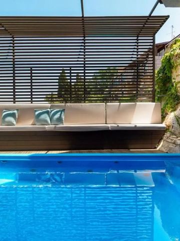 Außenpool mit Liegen und grüner Wand im Hintergrund