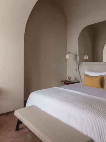 Elegantes Hotelzimmer mit großem Bett und stilvollem Dekor in neutralen Tönen.