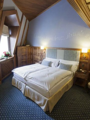 Dachzimmer mit elegantem Design und Holzverkleidung im Grand Hôtel Des Alpes