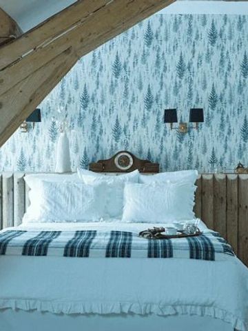 Hotelzimmer mit Holzbalken und blauer Tapete im rustikalen Stil