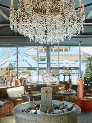 Luxuriöser Barbereich mit Kristallleuchter und Bergblick