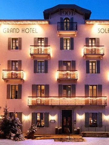 Beleuchtete Fassade des Grand Hotel Soleil d'Or bei Abenddämmerung