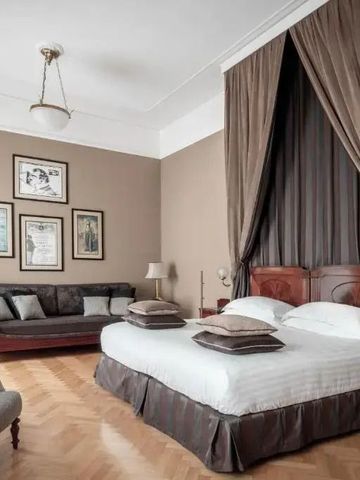 Großes Schlafzimmer mit Vorhängen und edler Möblierung