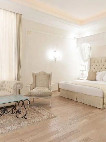 Luxuriöses Schlafzimmer mit Kingsize-Bett, weißen Möbeln und hellem Holzboden