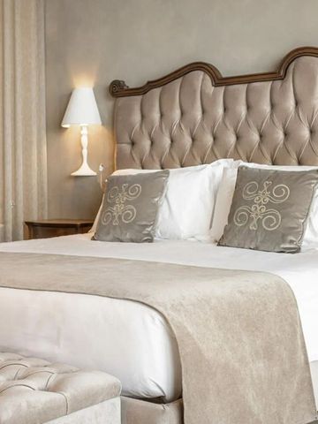 Elegantes Doppelzimmer mit gepolstertem Kopfteil und klassischen Einrichtungsdetails