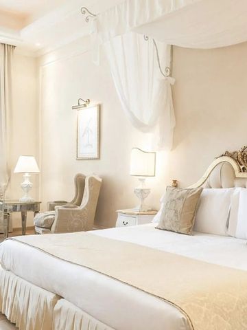 Helles, luxuriöses Schlafzimmer mit Himmelbett und klassischem Dekor