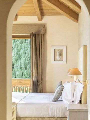 Elegantes Hotelzimmer mit Holzbalkendecke und Blick auf einen Baum