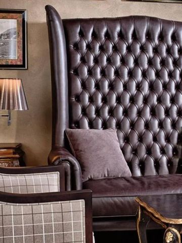 Gemütliche Sitzecke mit großen Sesseln und Ledercouch.