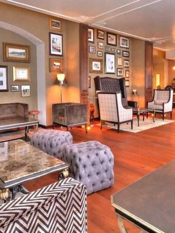 Großer Raum mit stilvollen Sesseln und Kunstwerken an den Wänden.