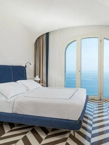 Elegantes Zimmer mit Meerblick und designer Bett in Blau.