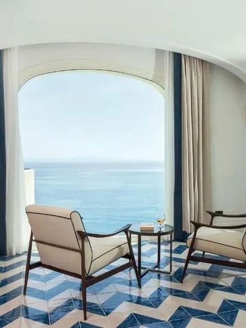 Zwei Sessel mit Panoramablick aufs Meer durch ein großes Fenster.