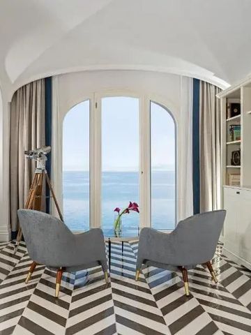 Sitzecke mit Meerblick und stilvollem Bodenmuster.