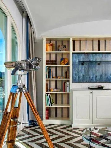 Elegante Suite mit Teleskop und Bücherregal mit Meerblick