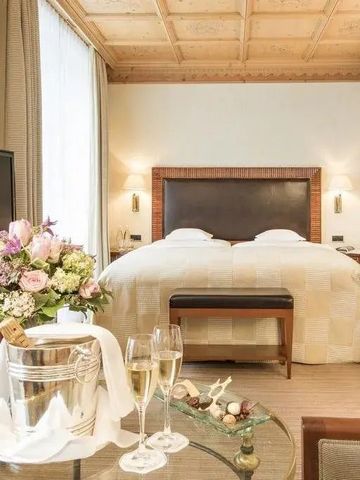 Gemütliches Hotelzimmer mit Blumen und Champagner auf dem Tisch