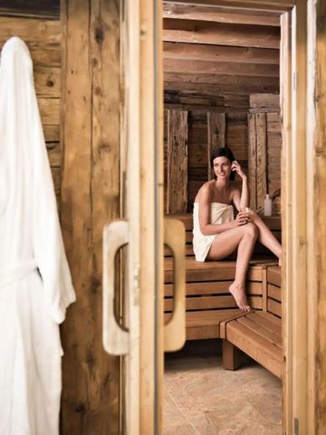 Frau in Sauna mit Holzinterieur.