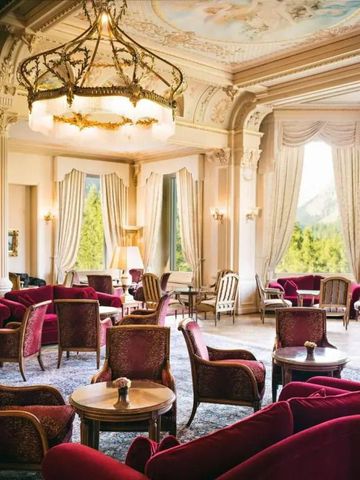Prunkvolle Lobby mit roten Sesseln und Kronleuchtern.