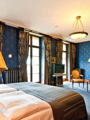 Luxuriöses Hotelzimmer mit blauer Tapete und eleganten Möbeln