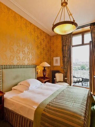 Edles Hotelzimmer mit goldener Tapete und Blick auf den Balkon