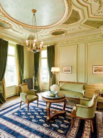 Elegantes Hotelzimmer mit klassischer Einrichtung und Stuckdecke