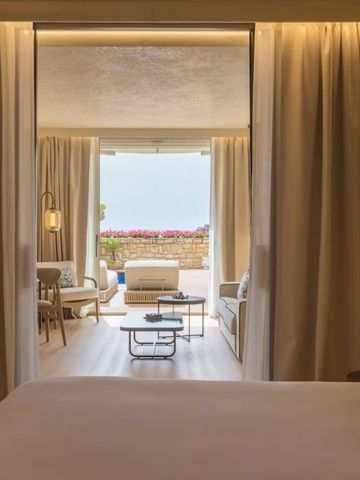 Elegantes Zimmer mit großem Bett und Balkon mit Meerblick