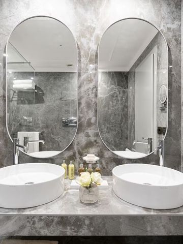 Luxuriöses Badezimmer mit Doppelwaschbecken und eleganter Marmorverkleidung