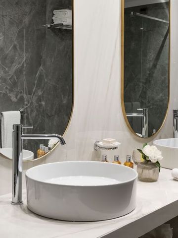 Elegant ausgestattetes Badezimmer mit modernen Armaturen und Spiegeln