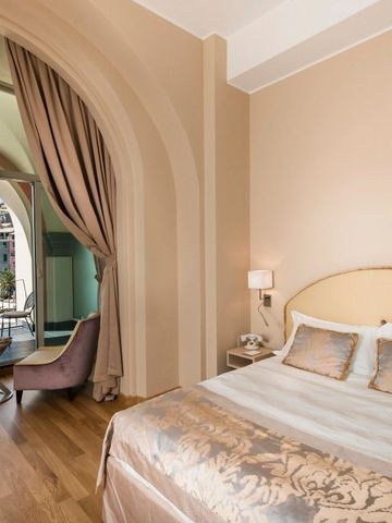 Luxuriöses Hotelzimmer mit großem Bett, eleganten Vorhängen und Blick auf das Meer.