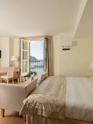 Großzügiges Hotelzimmer mit Meerblick, Doppeltür und hochwertigen Möbeln.